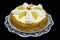 Delicious appetizing cake with nuts, pineapple, cream on a white lace napkin and a plate