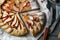 Delicious apple galette with pecans and knife on wooden table, flat lay