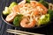 Delicious Asian udon noodles with shrimps and broccoli closeup o