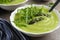 Delicious asparagus soup served on marble table, closeup