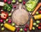 Delicious assortment of farm fresh various vegetables lined frame with a chopping board in the middle on wooden rustic background