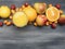 Delicious assortment of fresh variety of fruits lined around a glass with juice, kumquat, strawberry, oranges, pear, lemon, a w