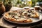 Delicious authentic stone baked mushroom pizza with rosemary on plate on wood table outdoors in summer nature. Italian cuisine