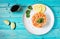 Delicious avocado and salted salmon tartar on blue wooden background