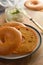 Delicious bagels with cream cheese on wooden board, pastry bread for breakfast