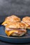 Delicious bagels with ham and cheese on table, closeup