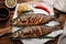 Delicious baked sea bass fish and ingredients on wooden table, flat lay