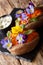 Delicious baked sweet potato with cream cheese decorated with edible flowers close-up. vertical