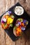 Delicious baked sweet potato with cream cheese decorated with edible flowers close-up. Vertical top view