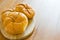 Delicious baking round buns made on a wooden table.