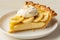 Delicious banana cream pie with whipped topping on a white plate