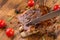 Delicious barbecued ribs seasoned with a spicy basting sauce on an old rustic wooden shopping board in a country kitchen