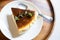 Delicious Basque Burnt Cheesecake,Tarta de Queso or San Sebastian Cheesecake cut one piece on a white ceramic plate with a spoon