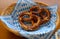Delicious Bavarian Brezeln or pretzels with a brown salty crust on a traditional Bavarian cocktail napkin in a basket