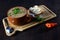 delicious bean broth with green onions, bacon, bread and pepper, typical brazilian food in porcelain bowl on wooden table
