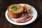 delicious bean broth with green onions, bacon, bread and pepper, typical brazilian food in porcelain bowl on wooden table