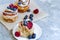 Delicious and beautiful berry rose puff pastries. Classic winter sweet dessert on blue background. French new year