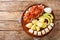 Delicious Bermuda breakfast made from salted cod with onion tomato sauce, boiled potatoes, eggs, banana and avocado close-up in a