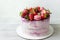 Delicious birthday cake with fresh strawberries, cherries, mint and french macaroons