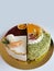 Delicious birthday cake on a white plate. Carrot cake, green velvet, strawberry cheesecake, mango cheesecake