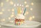 Delicious birthday cupcake with burning candles on plate