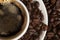 Delicious black coffee in a Cup of espresso, top view. coffee beans scattered