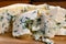 Delicious blue puff cheese on a wooden board. Tasty pleasing cheese prepared for a meal