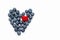 Delicious blueberries and tibetan raspberries formed into a heart shape on white background