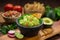 A delicious Bowl of Guacamole next to fresh ingredients on a table with tortilla chips and salsa