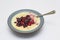 A delicious bowl of hot porridge with a forest fruit selection and a honey drizzle