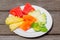 Delicious breakfast of fresh fruit on a plate - watermelon, melon, lime, papaya, pineapple and mint on old wooden background