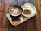 Delicious Breakfast; Heart love Latte art coffee in Black cup and Croissant topped with icing sugar