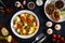 Delicious breakfast - scrambled eggs with onion, feta cheese, cherry tomatoes, champignons and chives on wooden table