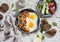 Delicious breakfast or snack - a fried egg, beans in tomato sauce with onions and carrots, fresh cucumbers and tomatoes, homemade