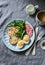 Delicious breakfast or snack - salami sausage, boiled egg, arugula, grilled bread and coffee on a gray background