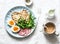 Delicious breakfast or snack - salami sausage, boiled egg, arugula, grilled bread and coffee on a light background