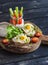 Delicious breakfast or snack - sandwich with cheese and a fried quail egg, greek yogurt, celery and sweet peppers on rustic woode