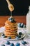 Delicious breakfast Sweet homemade stack of Oat pancakes with berries, honey, maple syrup, and milk bottle on wooden