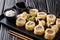 Delicious breakfast Tamagoyaki set sushi roll with rice, omelette, cheese, salmon and avocado close-up with sauces, wasabi and