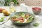 Delicious bresaola salad in bowl, fork and ingredients on light table