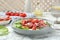 Delicious bresaola salad with tomatoes and parmesan cheese served on white marble table, closeup