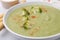 Delicious broccoli cream soup served on light table, closeup