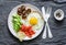 Delicious brunch - fried egg, avocado, cherry tomatoes and smoked salmon on grey background