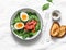 Delicious brunch - spinach, smoked salmon, soft boiled egg on a light background, top view. Healthy eating diet