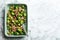 Delicious Brussels sprouts with bacon on white marble table, top view. Space for text