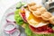 Delicious bubble waffle with fried egg on wooden board, closeup