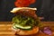 Delicious burger with flying ingredients on dark concreate background