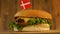 Delicious burger with small Danish flag on top of them with toothpicks. Yummy hamburger rotating.