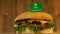 Delicious burger with small flag of Saudi Arabia on top of them with toothpicks. Yummy hamburger rotating.