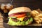 Delicious burger, soda drink and french fries served on wooden table, closeup